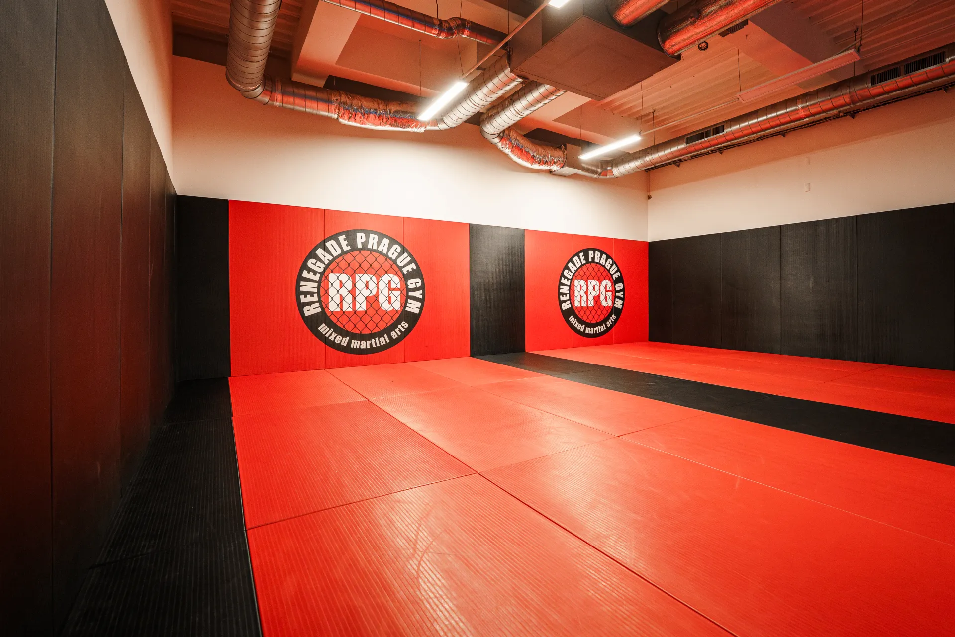 Grappling a BJJ místnost Renegade Prague Gym s červeno-černými tatami